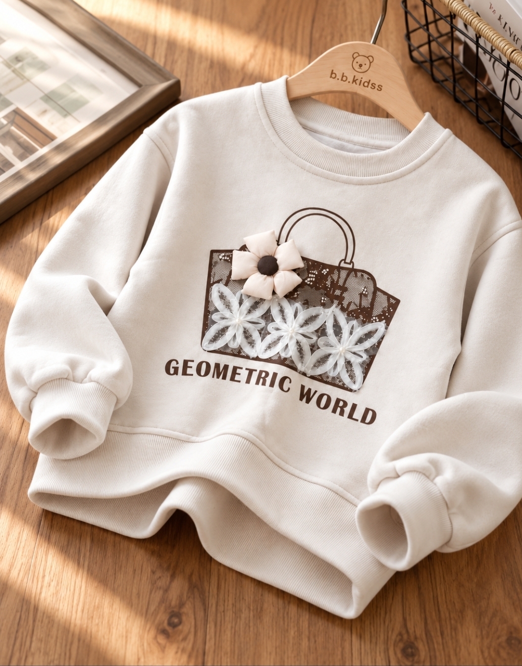 دورس دخترانه وارداتی مدل جیومتریک ورلد (Geometric World)، کرم شیری با طرح کیف قهوه‌ای و گل‌های توری و پارچه‌ای برجسته، یقه گرد و آستین بلند