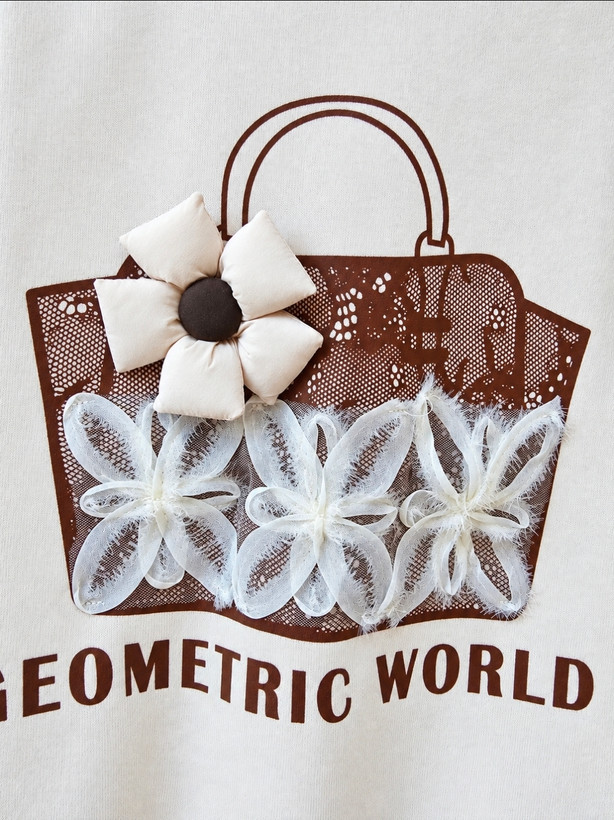 دورس دخترانه وارداتی مدل جیومتریک ورلد (Geometric World)، کرم شیری با طرح کیف قهوهای و گلهای توری و پارچهای برجسته، یقه گرد و آستین بلند
