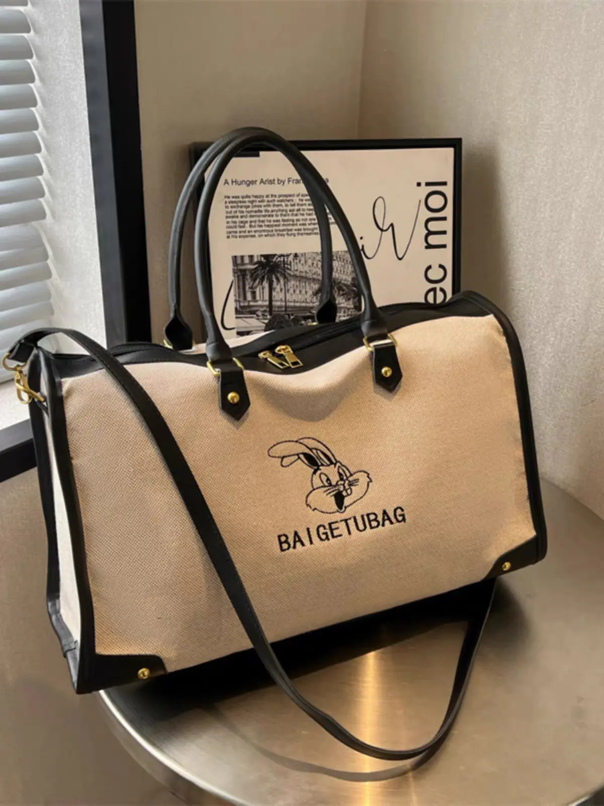 ساک ورزشی و سفری اسپرت وارداتی مدل ربیت کانواس (Rabbit Canvas)، کرم با جزئیات چرمی مشکی و قهوه‌ای، دارای بند دوشی قابل تنظیم و آستر داخلی
