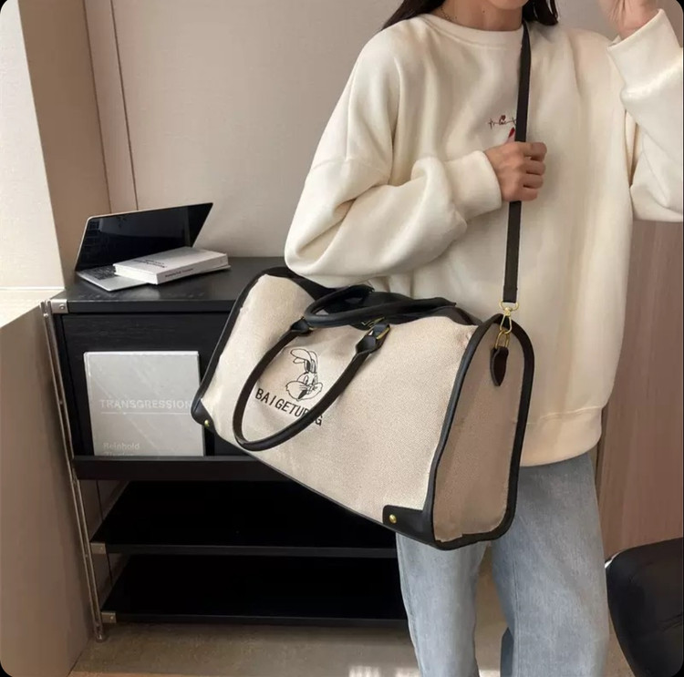 ساک ورزشی و سفری اسپرت وارداتی مدل ربیت کانواس (Rabbit Canvas)، کرم با جزئیات چرمی مشکی و قهوهای، دارای بند دوشی قابل تنظیم و آستر داخلی