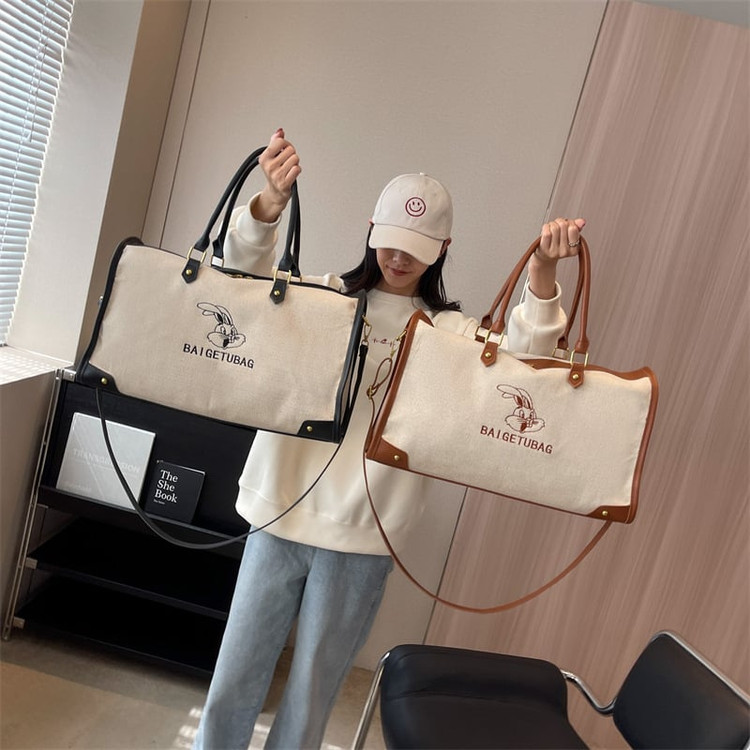 ساک ورزشی و سفری اسپرت وارداتی مدل ربیت کانواس (Rabbit Canvas)، کرم با جزئیات چرمی مشکی و قهوهای، دارای بند دوشی قابل تنظیم و آستر داخلی